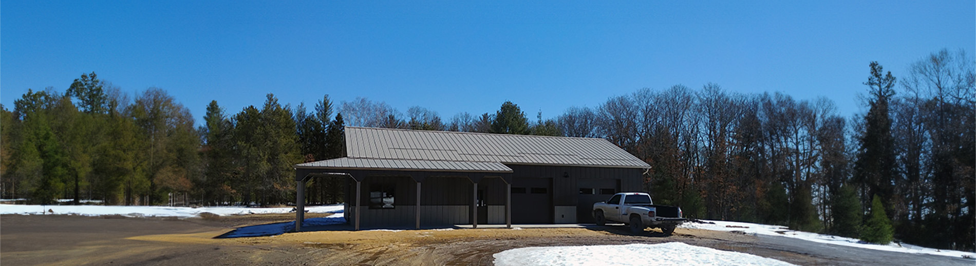 StewBer Buildings featured project: grey and beige suburban workshop located in City Point, Wisconsin with wraparound porch and awning and a truck parked in front